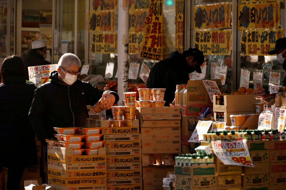 FILE PHOTO: Shoppers check foods at a supermarket in Tokyo