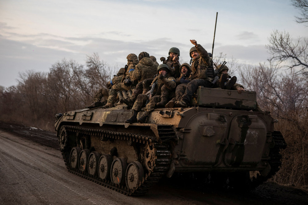 Ukrainian servicemen sit atop a BMP-2 infantry fighting vehicle on a road outside the frontline town of Bakhmut