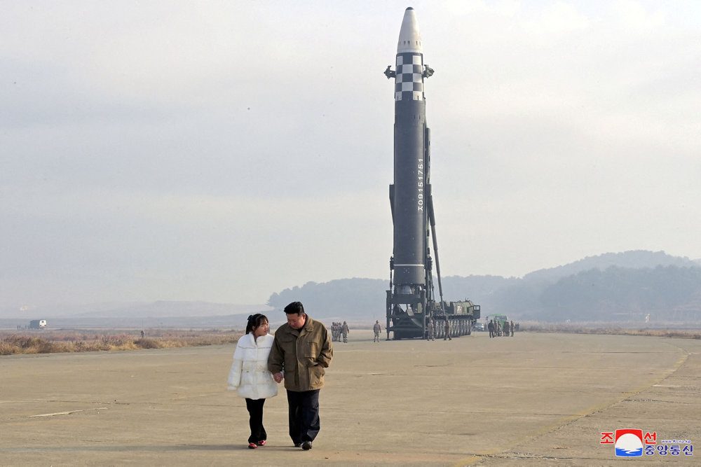 FILE PHOTO: North Korean leader Kim Jong Un, along with his daughter, walks away from an ICBM in this undated photo released by KCNA