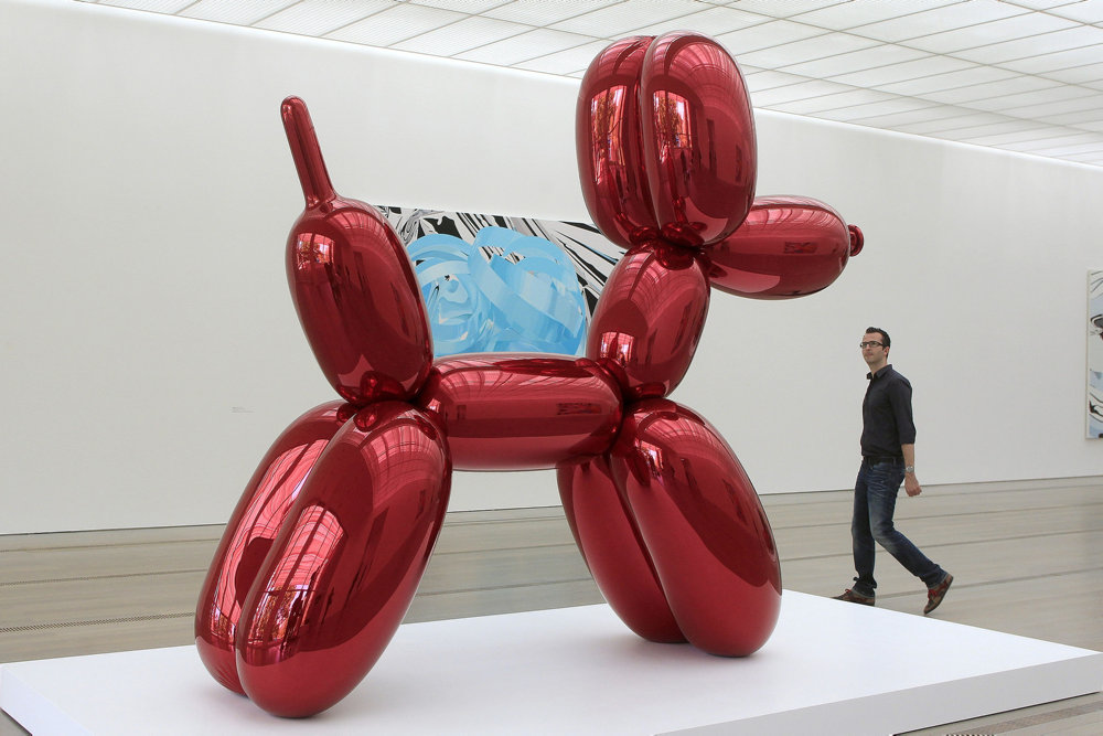 A man walks past the sculpture ''Balloon Dog (Red)'' by U.S artist Koons during a media preview at the Fondation Beyeler in Riehen