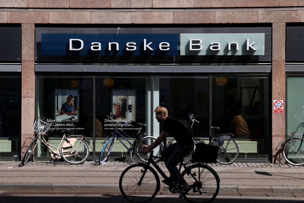 FILE PHOTO: A person rides a bicycle past a Danske Bank branch in Copenhagen