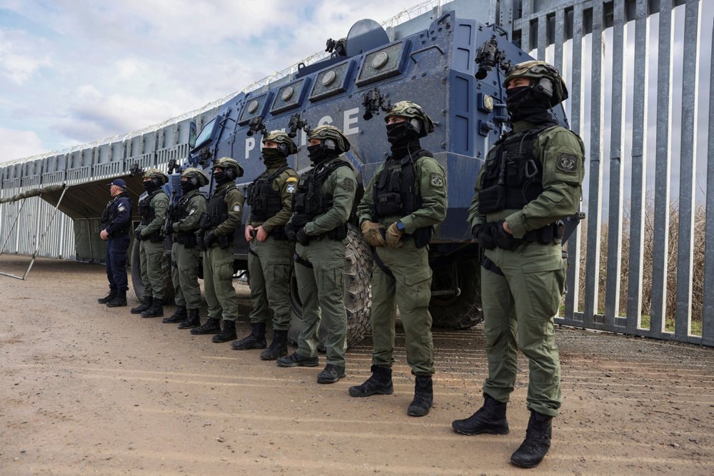 Greek police officers line up next to a border fence to prevent migrant crossings, during a press tour at the Greek-Turkish border