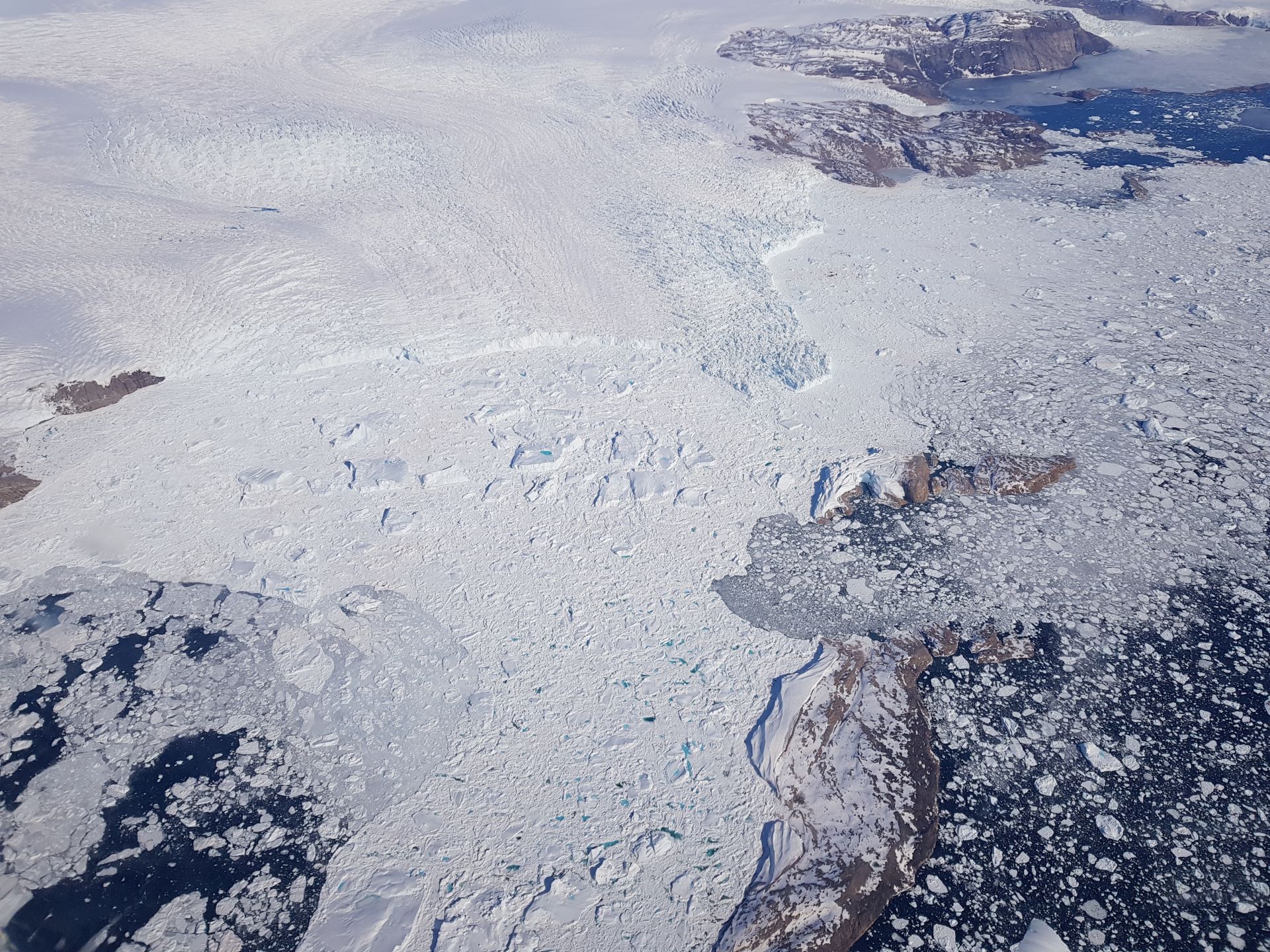 Gletsjer i Nordvestgrønland, der løber ud i havet. Tunneller under Indlandsisen kan få isen til at bevæge sig hurtigere mod havet. Foto: Baptiste Vandecrux (GEUS).