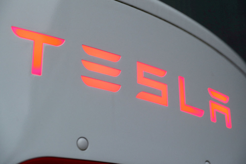 FILE PHOTO: The logo of Tesla is seen at a Tesla Supercharger station