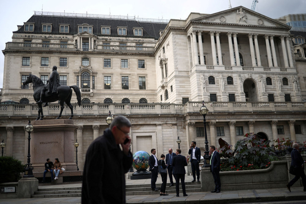 FILE PHOTO: People stand outside the Bank of England in the City of London financial in London