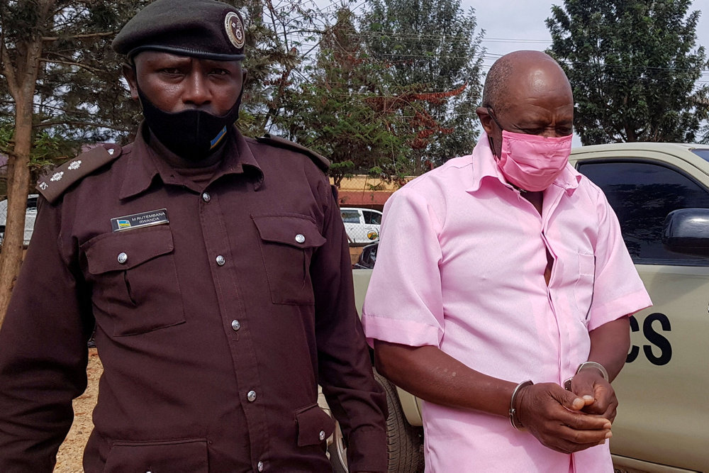 FILE PHOTO: Paul Rusesabagina, portrayed as a hero in a Hollywood movie about Rwanda''s 1994 genocide, is escorted in handcuffs into a courtroom, in Kigali