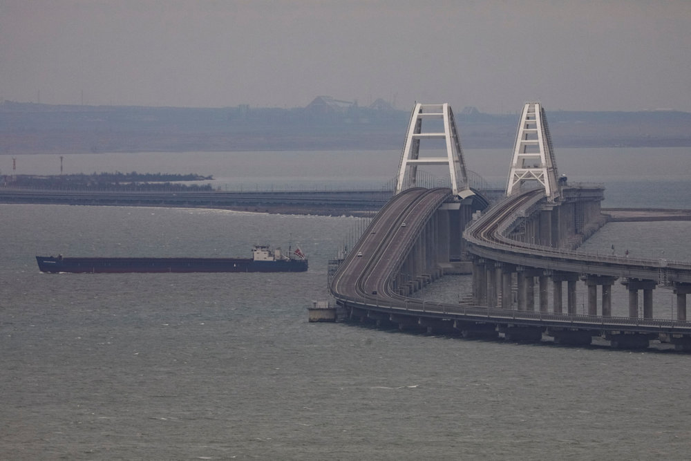 A cargo ship sails next to the Crimea bridge in the Kerch Strait