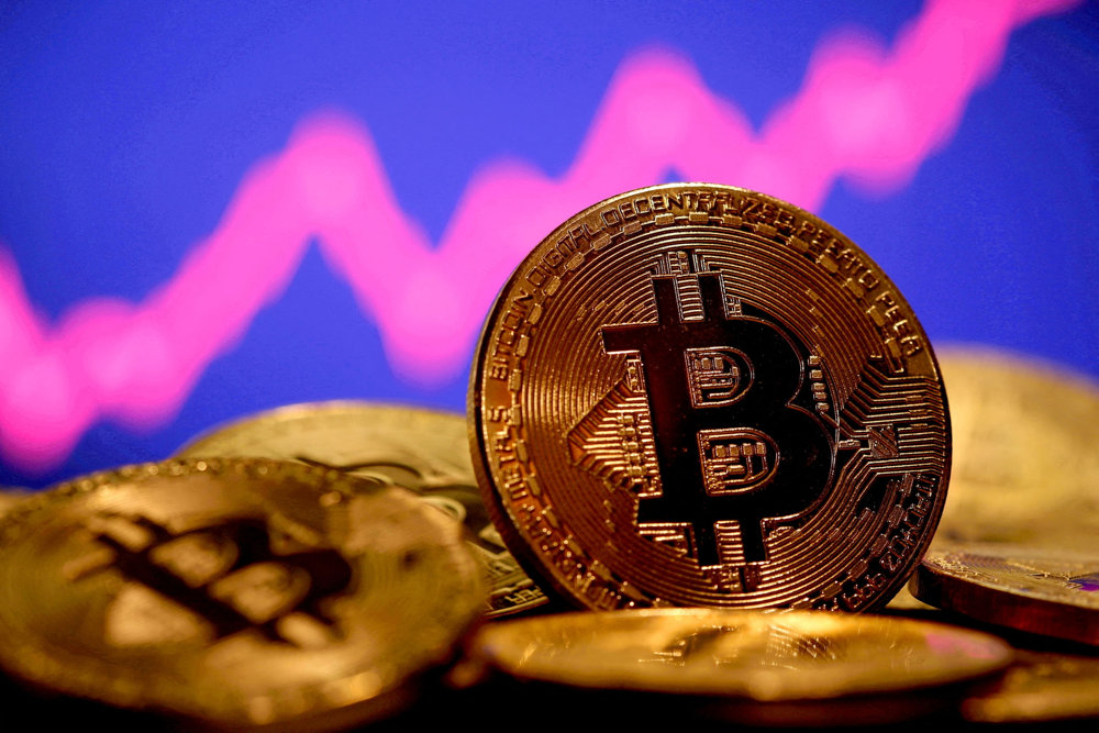 FILE PHOTO: A representation of virtual currency Bitcoin is seen in front of a stock graph in this illustration taken