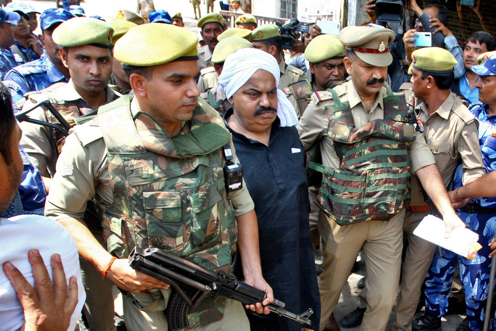 Police officers escort Atiq Ahmed outside a court in Prayagraj