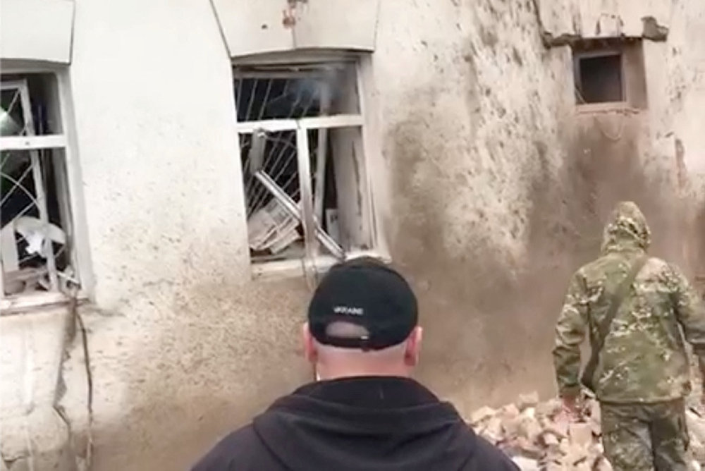 People inspect the site of a shilling in Kupjansk