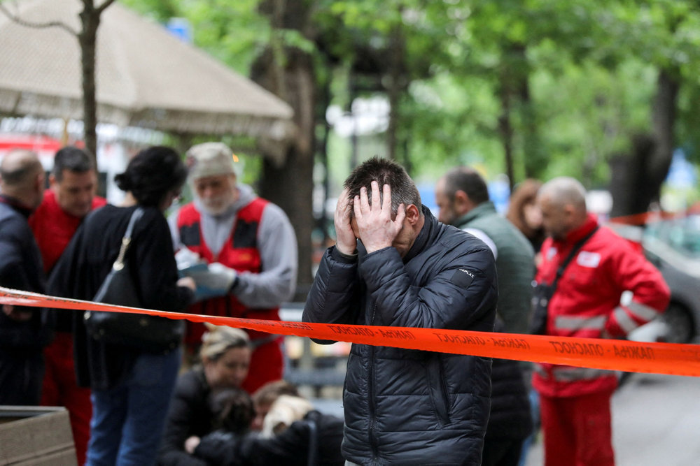 People react after a 14-year-old boy opened fire om other students and security guards at a school in downtown Belgrade