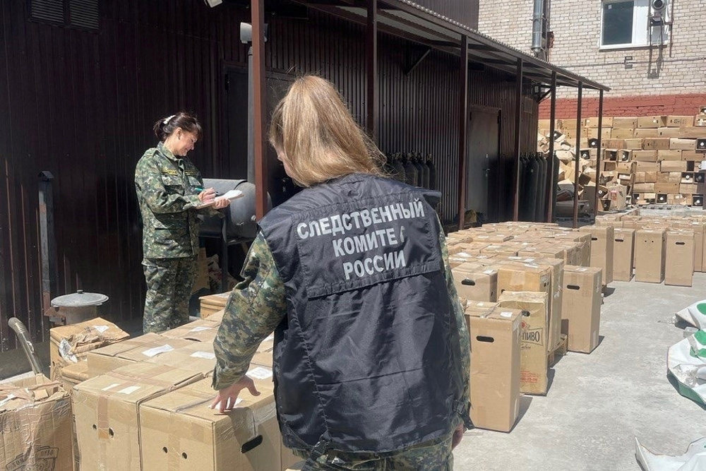 Investigators work at a factory where the alcohol-containing drink called