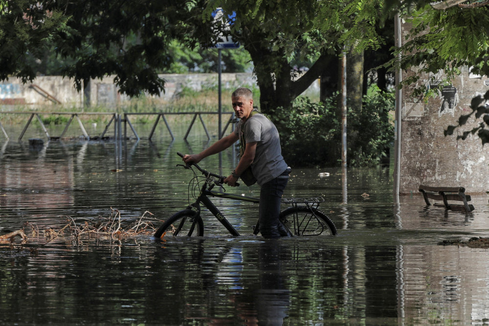 Local resident walks on a flooded street after the Nova Kakhovka dam breached, in Kherson