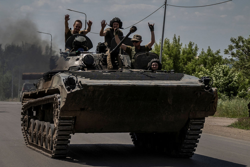 Ukrainian service members ride a BMP-1 infantry fighting vehicle near the front line city of Bakhmut