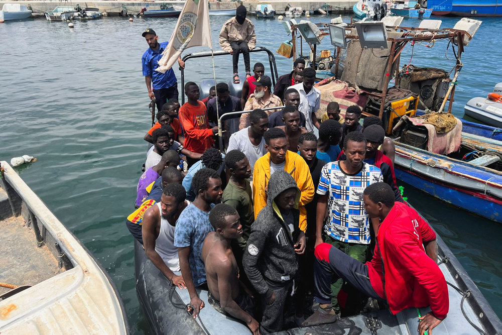 Migrants, whose boats sank in the sea and who were rescued by the Libyan Coast Guards at the Mediterranean Sea, arrive on a boat at the port, in Garaboli