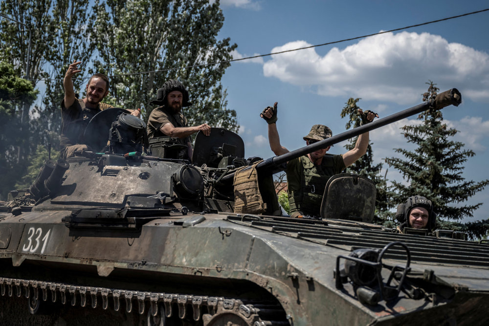 Ukrainian service members ride a BMP-1 infantry fighting vehicle near the front line city of Bakhmut