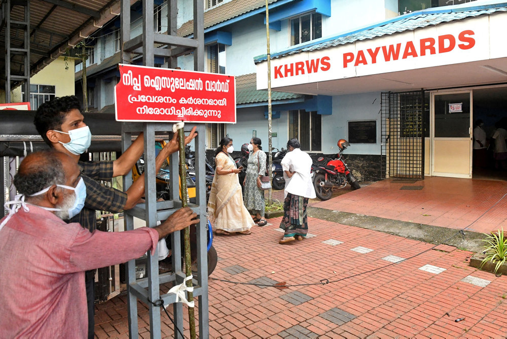 Staff install a sign reading