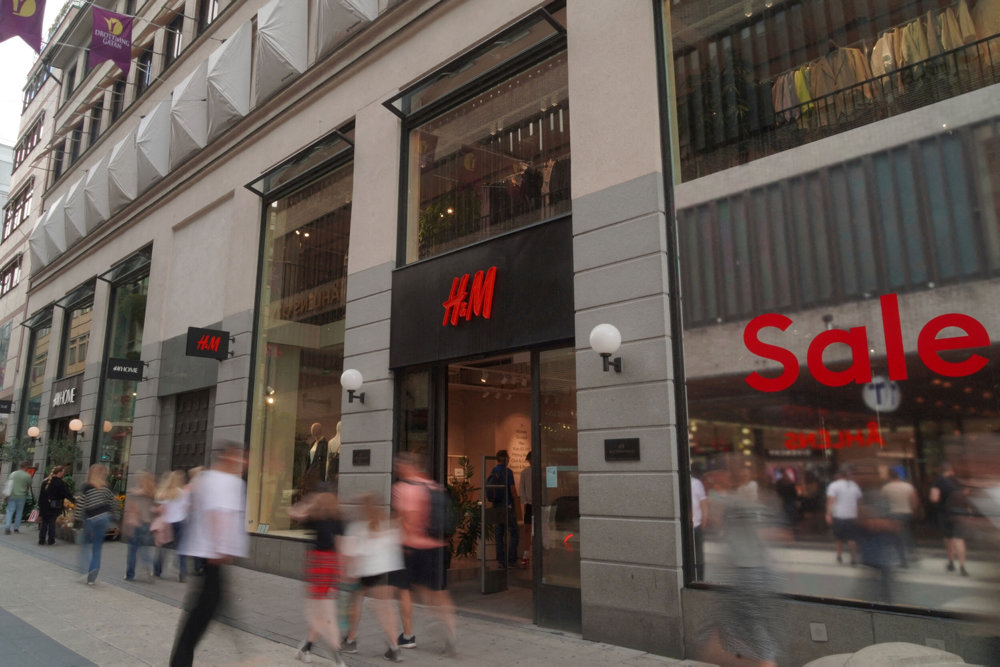 FILE PHOTO: Pedestrians and shoppers walk past a branch of fashion retailer H