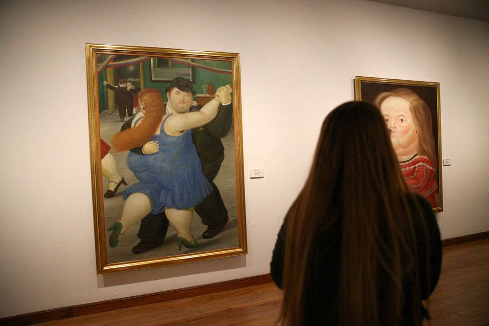 A woman looks at paintings by the artist Fernando Botero at the Botero Museum in Bogota