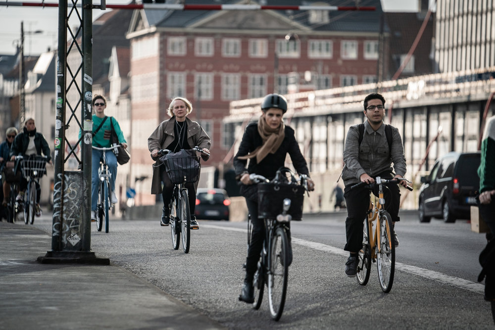 Cyklister og fodgængere i gadebilledet en tidlig morgen