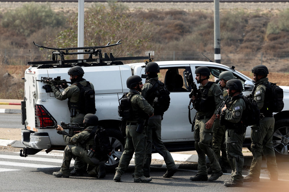 Israeli security take position on a road following a mass infiltration by Hamas gunmen from the Gaza Strip, near Sderot