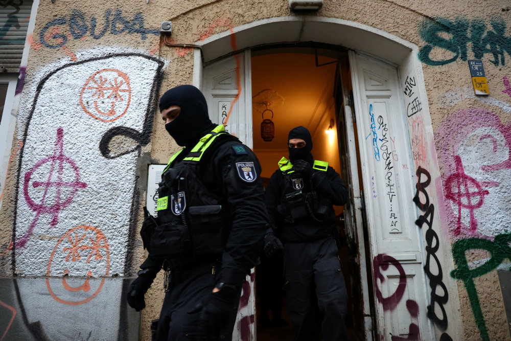German police officers leave a house during a raid against people supporting the Palestinian Islamist group Hamas, in Berlin