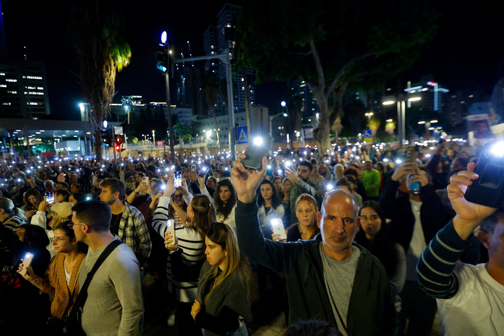 People gather as they await news of hostages expected to be released by Hamas, in Tel Aviv