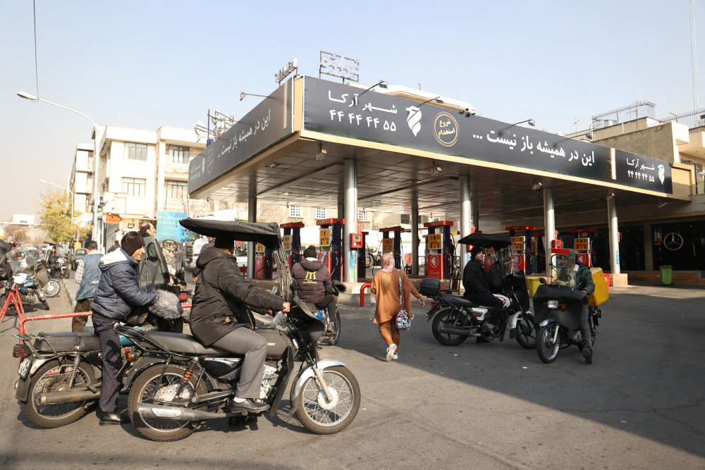 People wait at a gas station during gas station disruption in Tehran